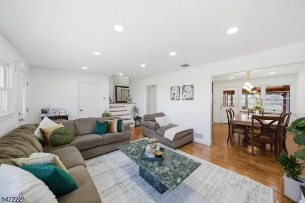 a living room with furniture wooden floor and kitchen view