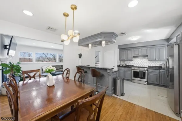 a kitchen with stainless steel appliances granite countertop a kitchen island a stove a table and chairs