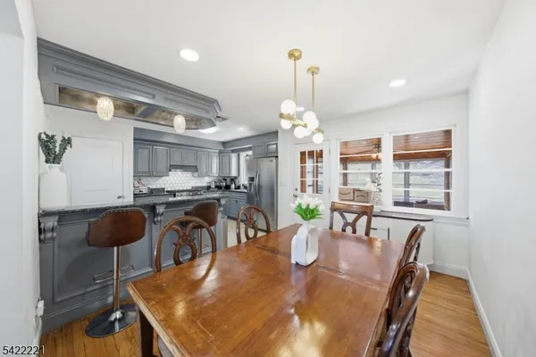 a kitchen with stainless steel appliances granite countertop a sink a stove and a dining table