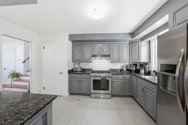 a kitchen with stainless steel appliances granite countertop a stove top oven a sink and dishwasher