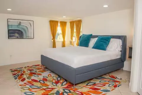 a bedroom with a bed and painting on the wall