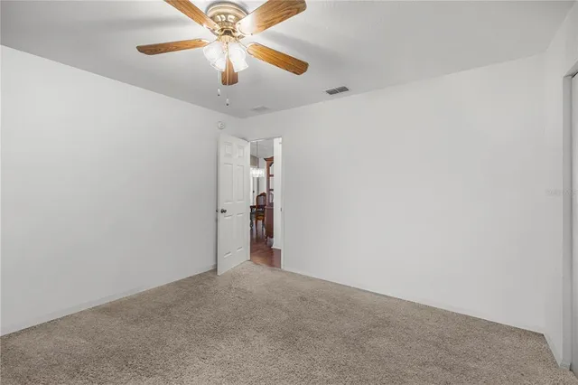 en empty room with window and ceiling fan