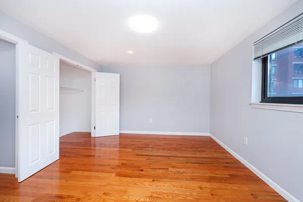 a view of an empty room with wooden floor