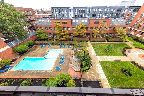 a front view of a multi story residential apartment building with yard