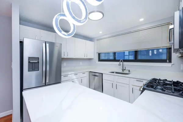 a kitchen with stainless steel appliances a sink a stove a refrigerator and cabinets