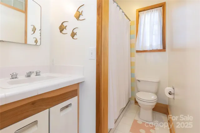 a bathroom with a granite countertop sink and a toilet