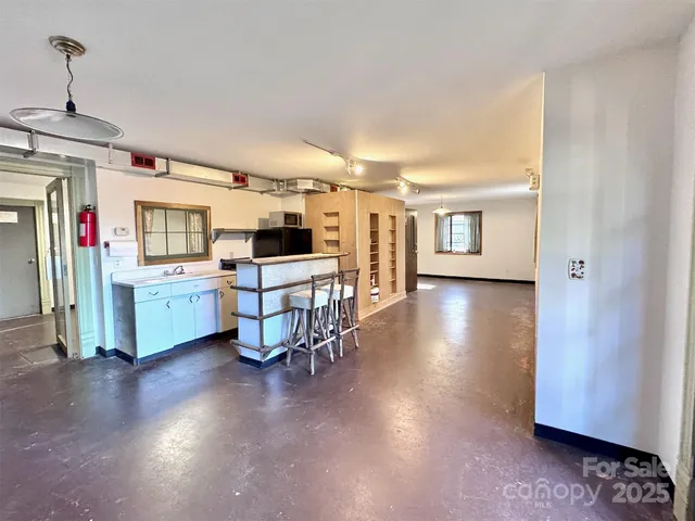 a view of a kitchen with furniture and wooden floor