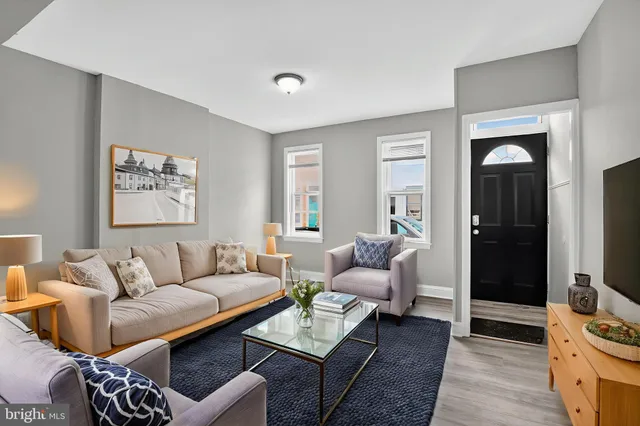 a living room with furniture a rug and a flat screen tv