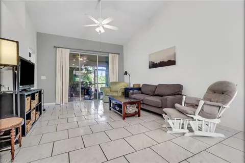 a living room with furniture a flat screen tv and a window