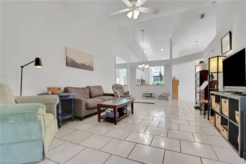 a living room with couches a flat screen tv and kitchen view