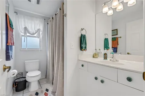 a bathroom with a toilet sink a mirror and shower