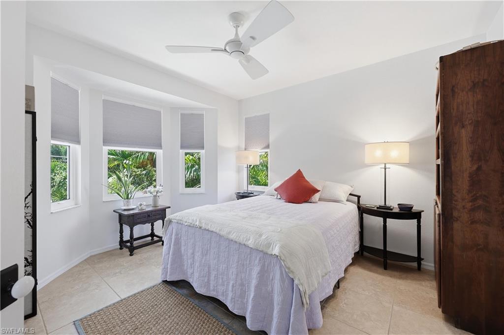 2958 Poplar Street Naples, FL 34112 - Photo 17 of 49 a bedroom with a bed and a table lamp
