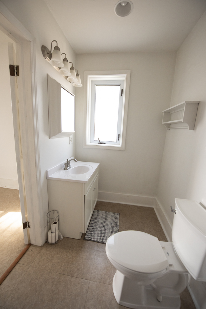 716 Locust Street Sterling, IL 61081 - Photo 14 of 27 a bathroom with a sink toilet and mirror