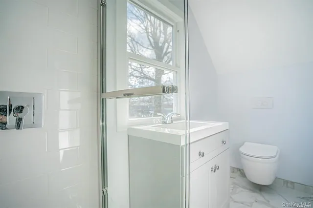 a bathroom with a sink toilet and window