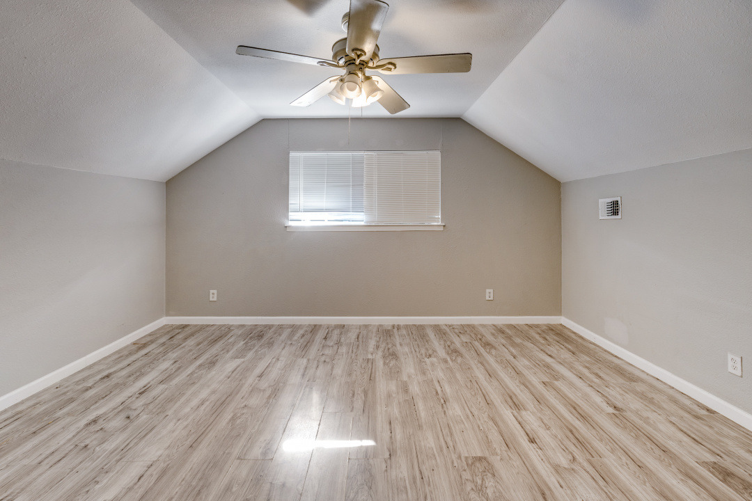 4709 Baton Rouge Street Houston, TX 77028 - Photo 5 of 16 Sloped ceilings rise above durable wood-look flooring in this versatile upper-level space.