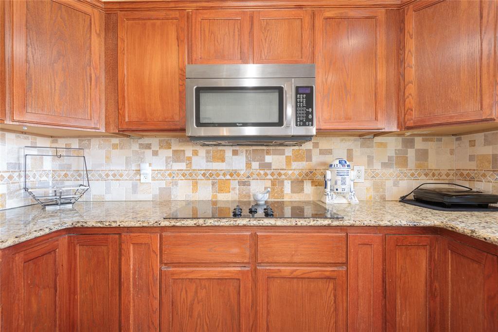 2005 Inverness Drive Carrollton, TX 75007 - Photo 13 of 25 a kitchen with granite countertop stainless steel appliances a stove a microwave and sink