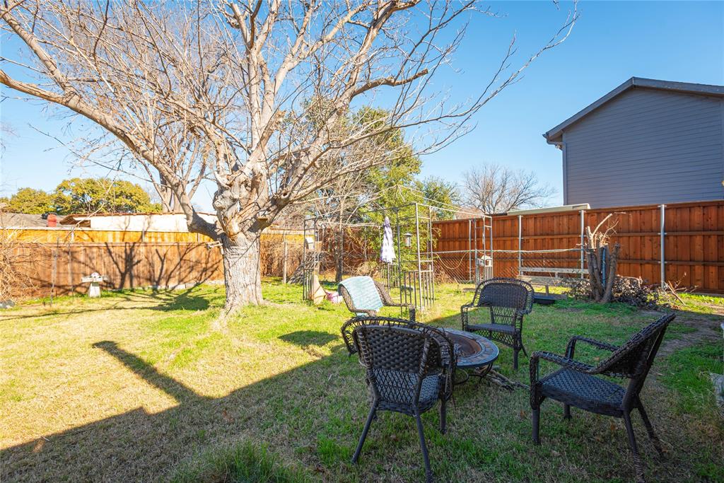 2005 Inverness Drive Carrollton, TX 75007 - Photo 23 of 25 a view of a backyard with table and chairs and a fire pit