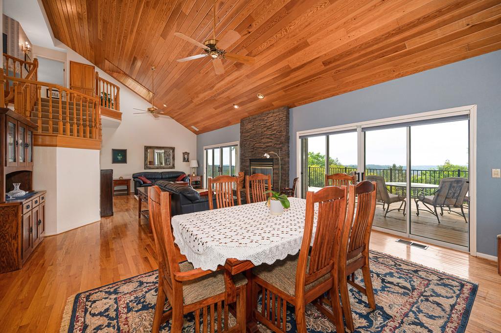 2358 Deer Ravine Court Cool, CA 95614 - Photo 11 of 63 dining area featuring ceiling fan, light wood-type flooring, a fireplace, and a vaulted wooden ceiling