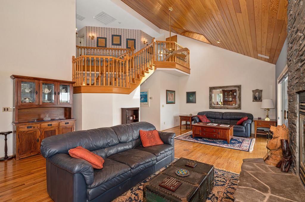 2358 Deer Ravine Court Cool, CA 95614 - Photo 12 of 63 living area with a stone fireplace, light wood-style flooring, a vaulted wooden ceiling, and hanging lights
