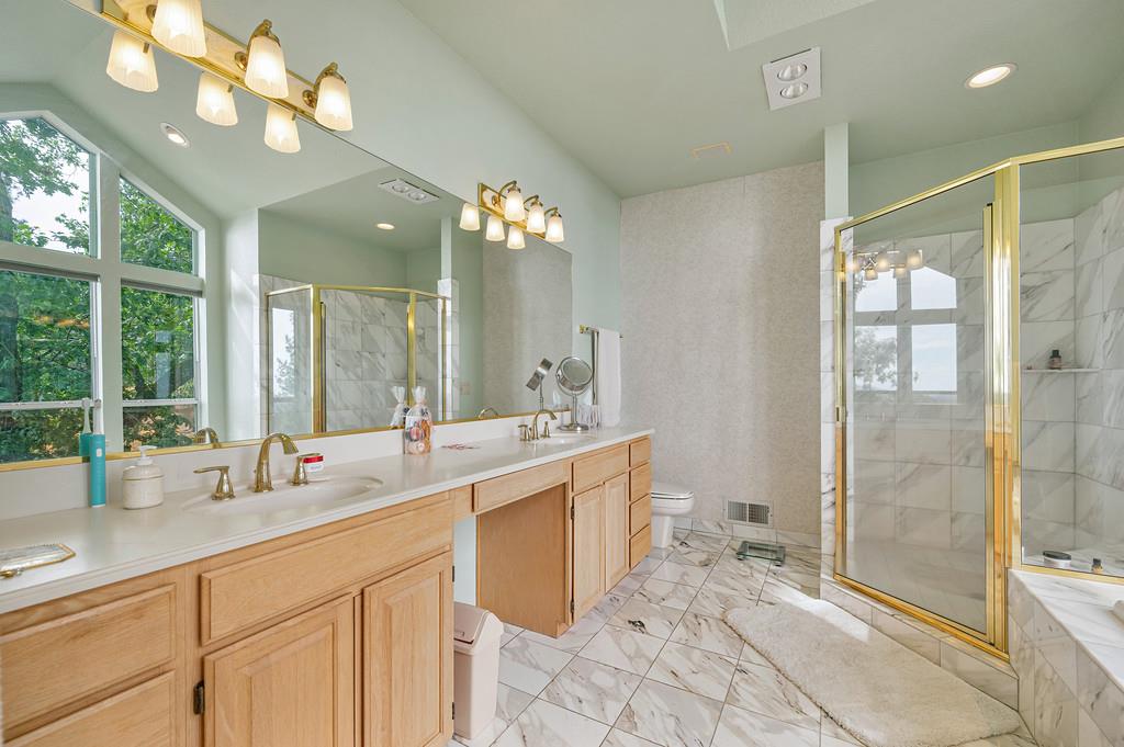 2358 Deer Ravine Court Cool, CA 95614 - Photo 19 of 63 primary bathroom featuring double vanity, a shower stall, recessed lighting, a garden tub, and light marble finish flooring