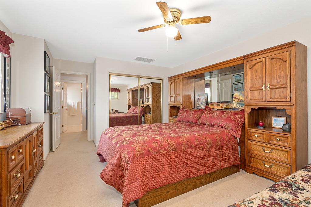 2358 Deer Ravine Court Cool, CA 95614 - Photo 26 of 63 a spacious bedroom with a bed a dresser and a chandelier