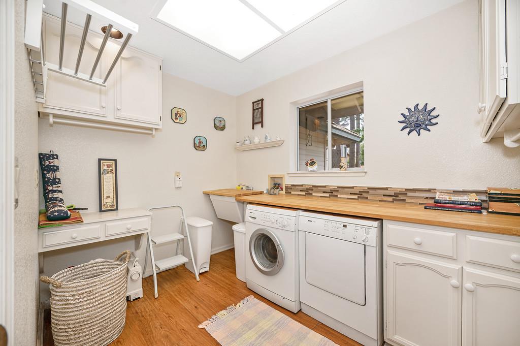 2358 Deer Ravine Court Cool, CA 95614 - Photo 27 of 63 laundry area with light wood-style flooring, separate washer and dryer, and cabinet space