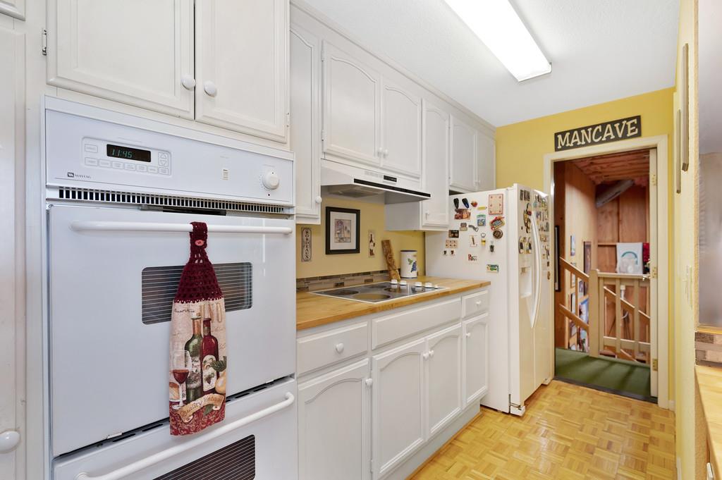 2358 Deer Ravine Court Cool, CA 95614 - Photo 36 of 63 Additional kitchen featuring white cabinetry, white appliances, and parquet floors