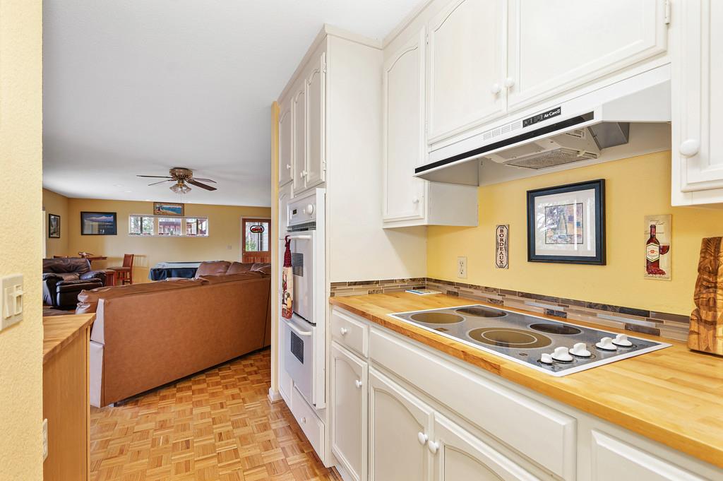 2358 Deer Ravine Court Cool, CA 95614 - Photo 63 of 63 additional kitchen downstairs featuring butcher block countertops, open floor plan, white cabinets, electric stovetop, and double oven