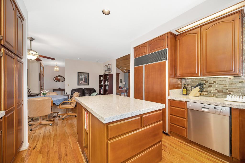 2358 Deer Ravine Court Cool, CA 95614 - Photo 60 of 63 kitchen featuring stainless steel dishwasher, paneled refrigerator, a kitchen island, open floor plan, and light wood-style floors