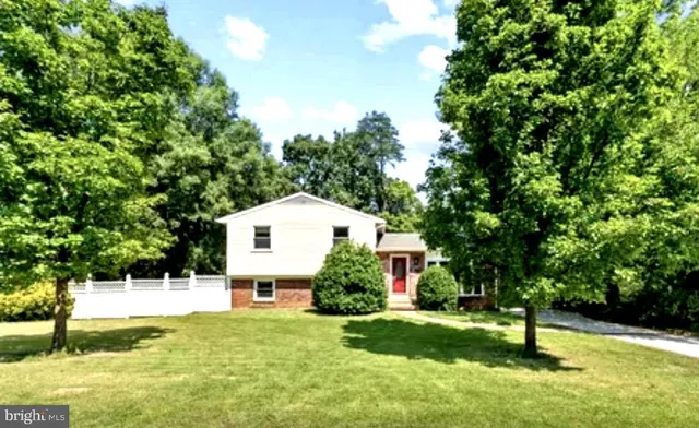 a front view of a house with a yard and tree