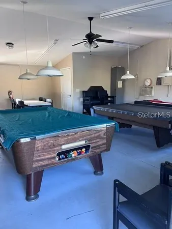 a living room with furniture pool table and chandelier