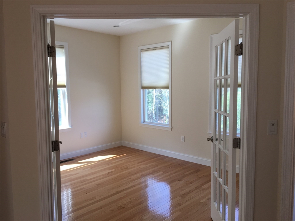 4 Reserve Way, Unit D Burlington, MA 01803 - Photo 11 of 17 a view of an empty room with wooden floor and a window