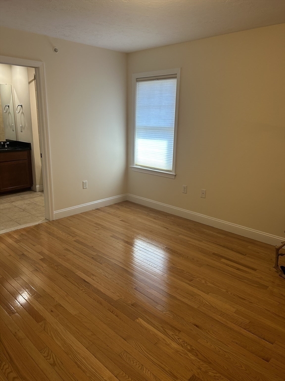 4 Reserve Way, Unit D Burlington, MA 01803 - Photo 13 of 17 a view of an empty room with wooden floor and a window