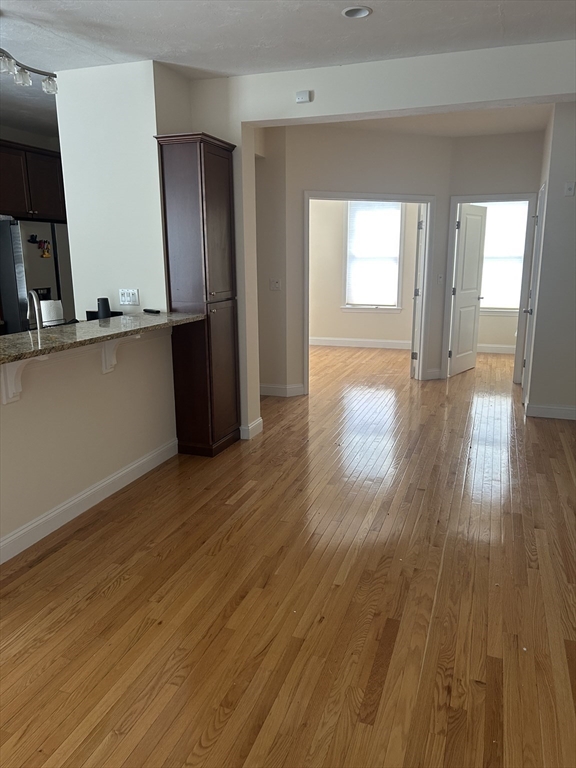 4 Reserve Way, Unit D Burlington, MA 01803 - Photo 8 of 17 a view of an empty room with window and wooden floor