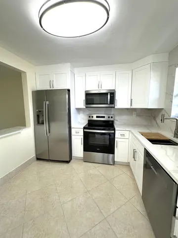 a kitchen with stainless steel appliances a refrigerator a stove a sink and a microwave