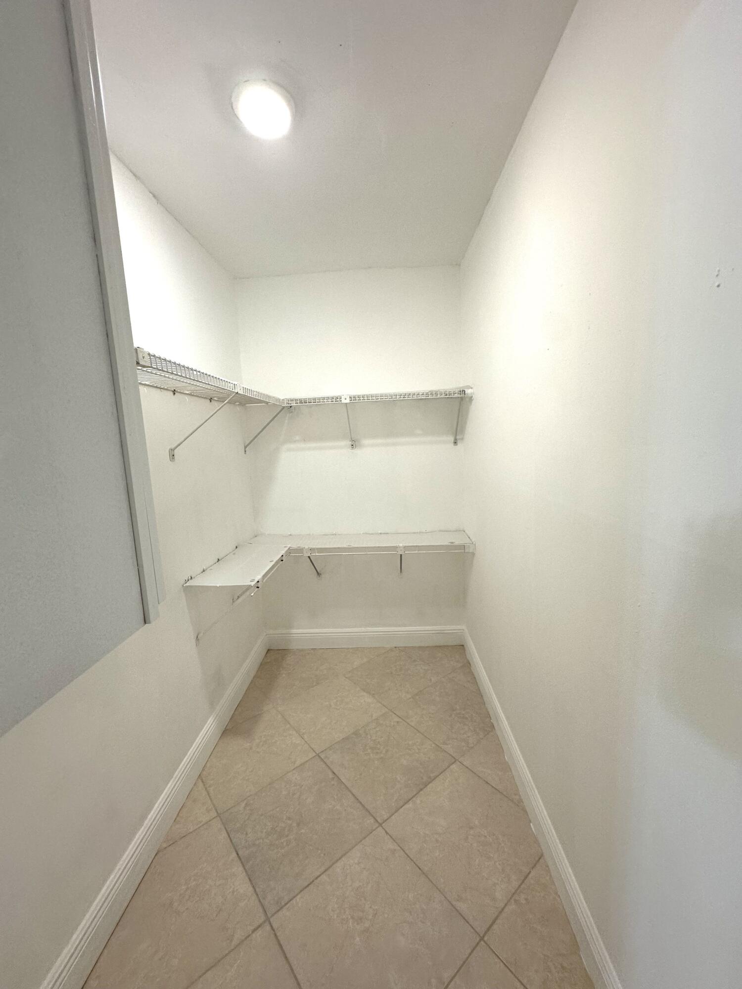 9440 Southwest 8th Street, Unit 109 Boca Raton, FL 33428 - Photo 7 of 14 an empty room with white walls and tiles