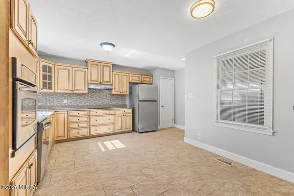 a large white kitchen with granite countertop a granite counter tops and a stove top oven