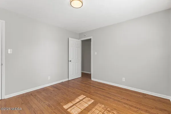 a view of an empty room with wooden floor