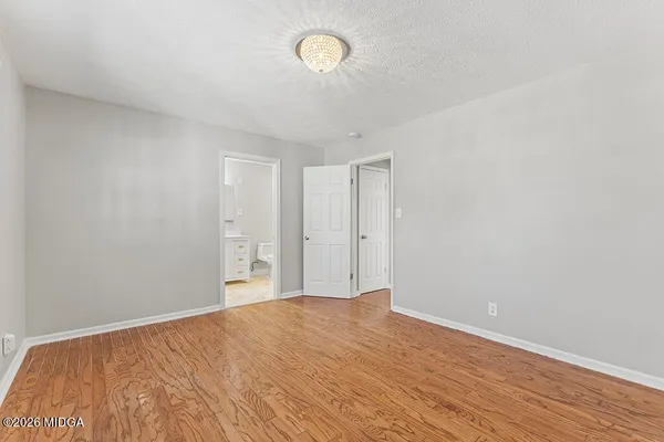 a view of empty room with wooden floor