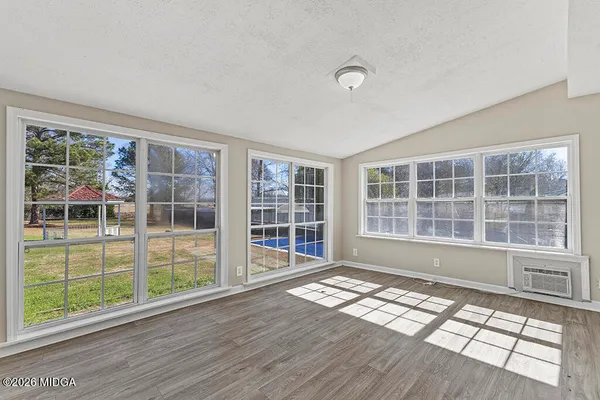 a view of empty room with windows and wooden floor
