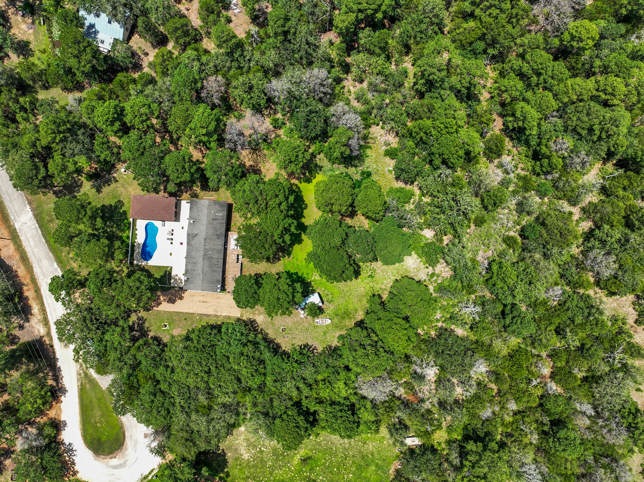 438 Kellar Road Smithville, TX 78957 - Photo 26 of 30 An aerial perspective showcases a secluded home nestled amongst dense, verdant woodlands, complete with a inviting private pool.