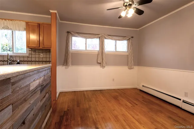 a view of a room with wooden floor and chandelier