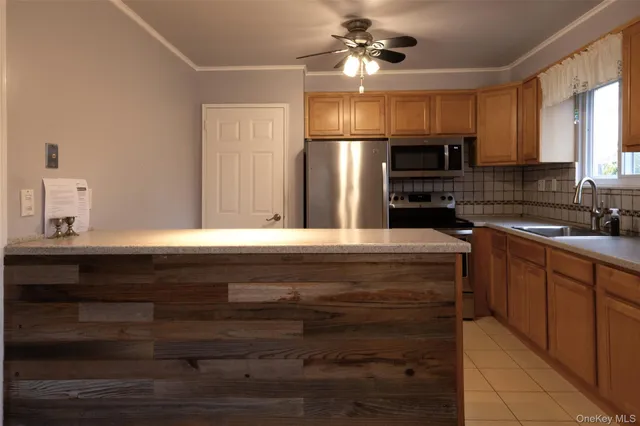 a kitchen with kitchen island a sink stainless steel appliances and cabinets