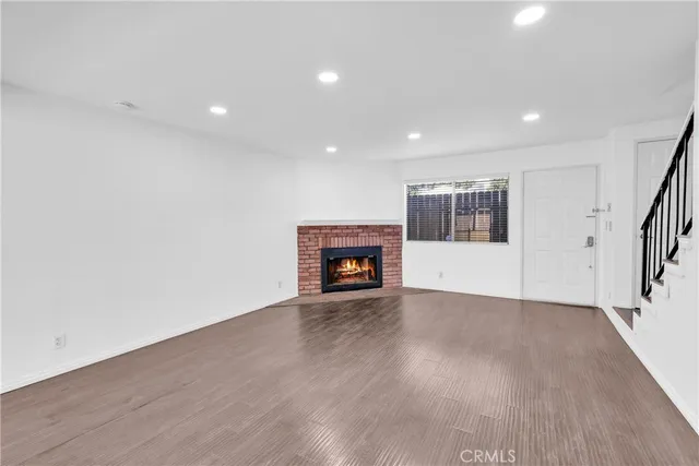 an empty room with wooden floor and fireplace