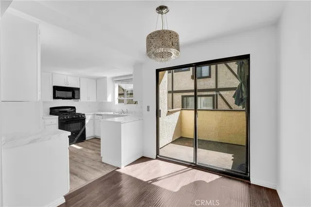 a view of a big room with wooden floor windows and a view of kitchen