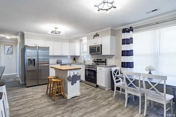 a kitchen with a table chairs refrigerator and microwave