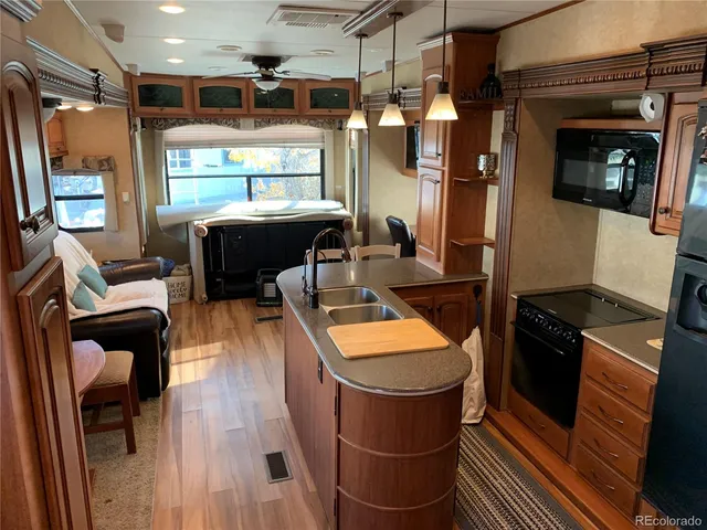 a kitchen with stainless steel appliances granite countertop a refrigerator a stove and a dining table with wooden floor