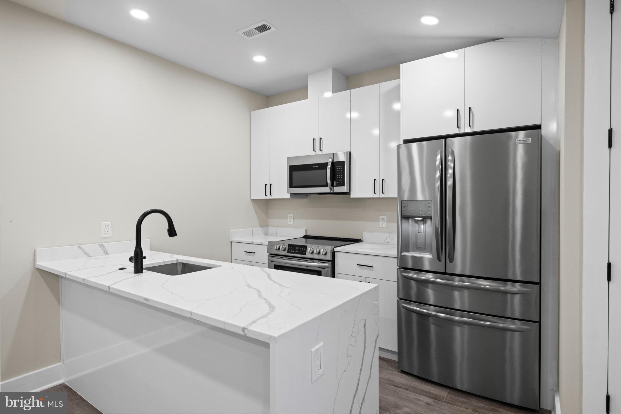 824 18th Street Northeast, Unit 12 Washington, DC 20002 - Photo 17 of 25 a kitchen with stainless steel appliances a refrigerator sink and microwave