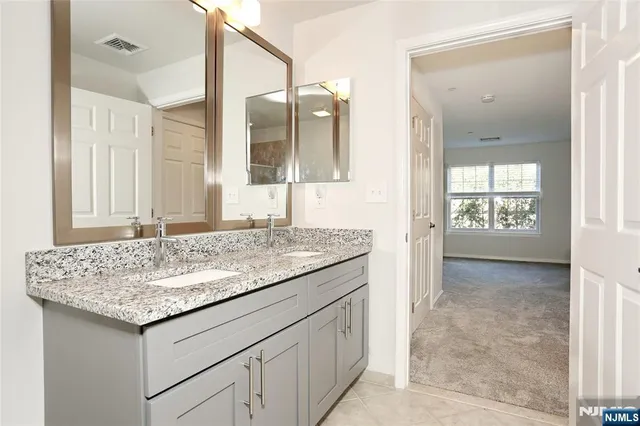 a bathroom with a granite countertop sink and a mirror