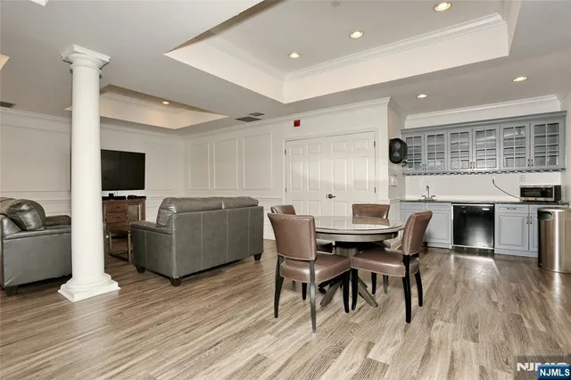 a living room with furniture kitchen view and a wooden floor